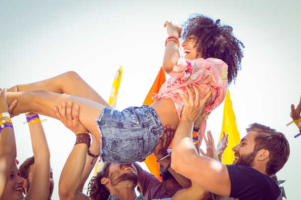 Happy hipster woman crowd surfing at a music festival-1